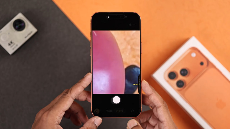 Finger sliding over iPhone Camera Control button for zooming