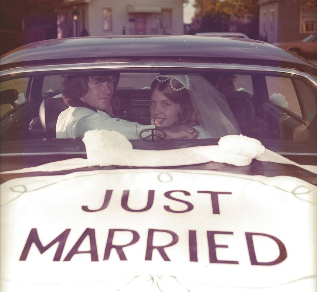 A couple inside a car looking through the back window at the camera