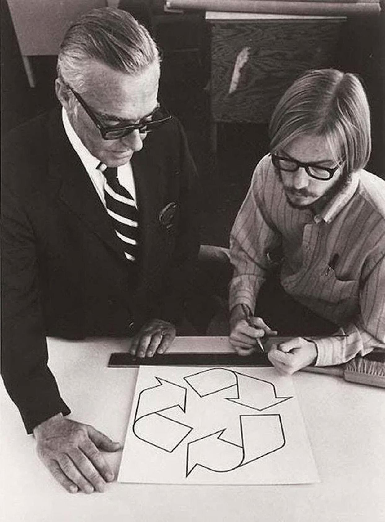 A man holding a pen looking at his design