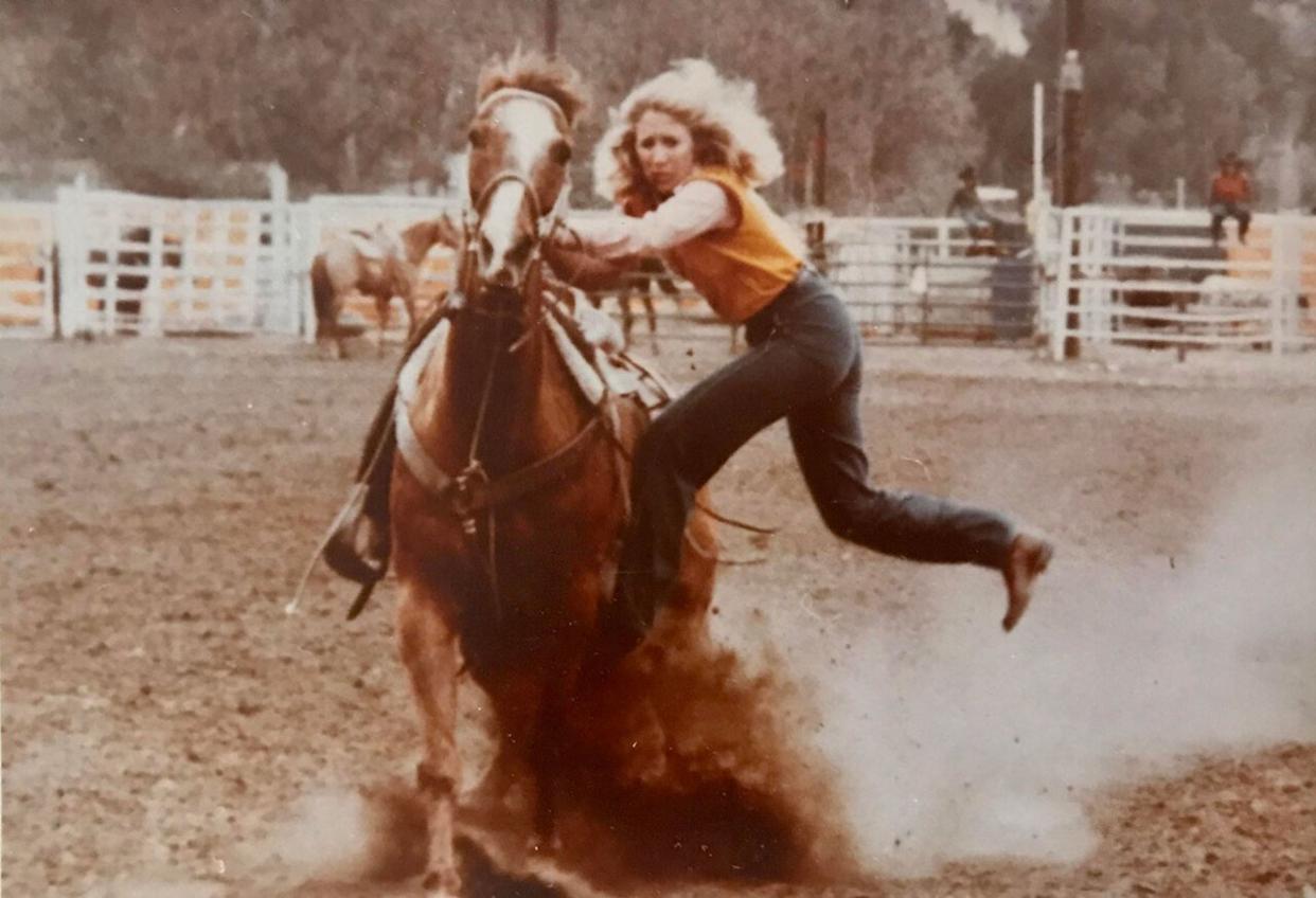 A woman riding a horse in a rodeo