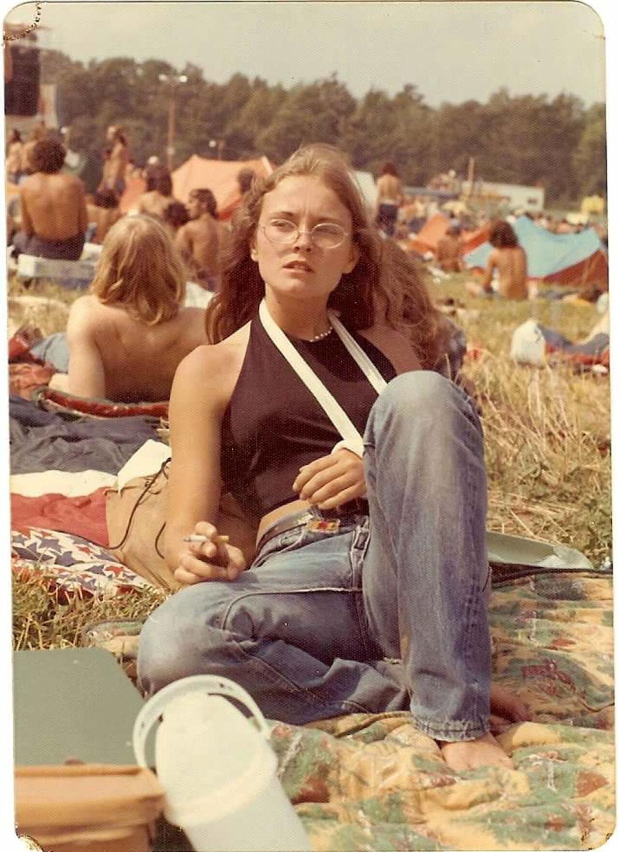 A young woman laying in a field at a concert