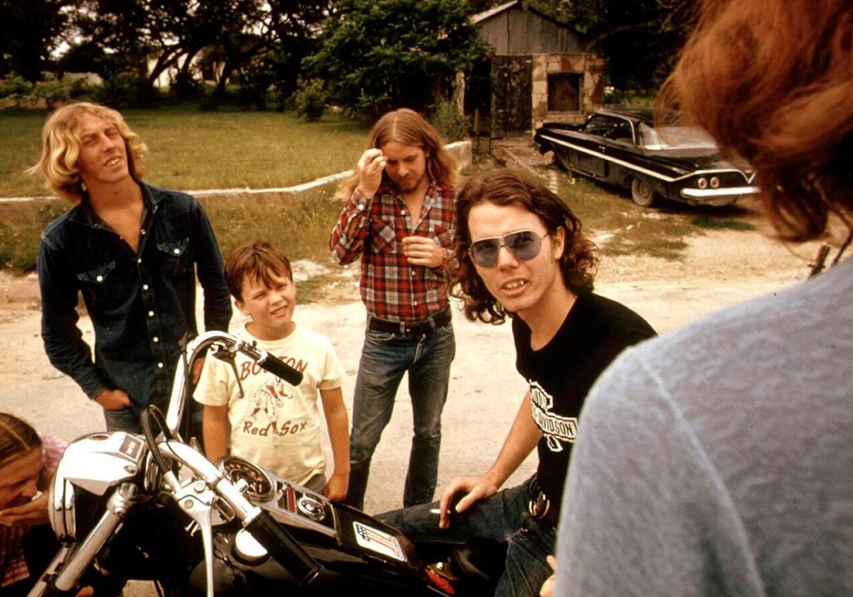 A man on a motorcycle talking with friends
